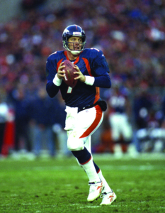 John Elway drops back to pass against the Seattle Seahawks at Mile High Stadium in Denver, CO on December 27, 1998.